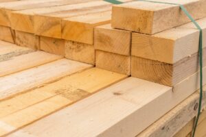 Stack of sawn timber planks bundled together at a lumber yard, showing raw cut wood texture and grain.